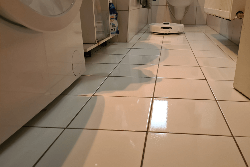 The Dreame L10s Ultra mops a tiled floor in the bathroom.
